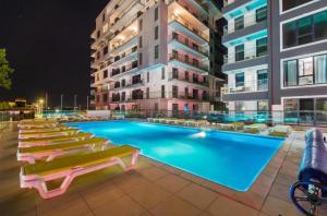 a swimming pool with lounge chairs and a building at Mamaia Sea Vibe in Mamaia Sat/Năvodari