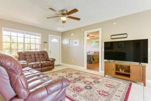 a living room with a couch and a flat screen tv at 6 Mi to Beach Port St Lucie Home with Fenced Yard in Eden