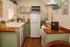 a kitchen with green cabinets and a white refrigerator at Lil Hickory in Hammondsport