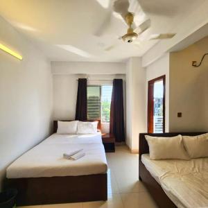a hotel room with two beds and a window at Falcon Beach Resort in Cox's Bazar +18 photos