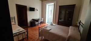 a room with two beds and a table and a window at Asmundo Palace Suites & Spa in Catania