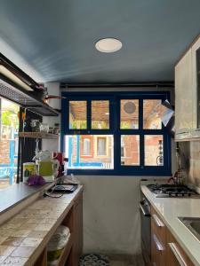 a kitchen with a counter and two windows at 5RoomsPansiyon in Edirne +48 photos