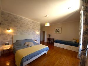a bedroom with a bed and a bench in it at Au pays de Jacquou : Chambre d’hôtes et table d’hôtes in Fossemagne