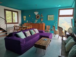 a living room with a purple couch and a table at That's amore - l'incanto della valle in Monchio