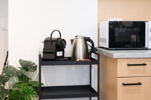 a black shelf with a microwave and a tea kettle at Bright City Apartment Free Parking & 2 Min to Subway in Vienna +8 photos