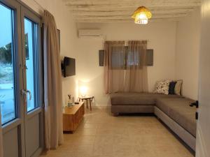 a living room with a couch and a window at Melia Sifnos Superior in Platis Gialos