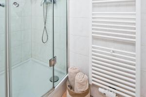 a shower with a glass door in a bathroom at Bright City Apartment Free Parking & 2 Min to Subway in Vienna