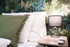 a bed with white pillows and a lamp on a table at Bright City Apartment Free Parking & 2 Min to Subway in Vienna