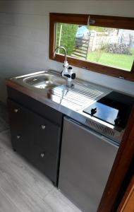 eine Küchentheke mit Spüle und Spüle in der Unterkunft La Salicorne hébergement insolite in Saint-Germain-sur-Ay