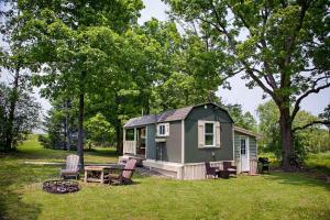 a green tiny house with a picnic table in a yard at Lil Hickory in Hammondsport