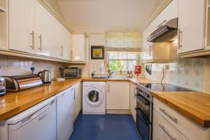 a kitchen with a washer and dryer in it at Castle Cottage No 2 in Acharn