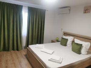a bedroom with a large bed with green curtains at Lovely Apartment With Courtyard in Mangalia