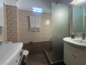 a bathroom with a sink and a toilet and a shower at Casa d'Angelo by Horizon Homes in Orfánion