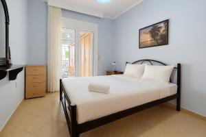 a bedroom with a bed and a television in it at Casa d'Angelo by Horizon Homes in Orfánion