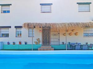 a pool in front of a building with a table and chairs at Cubo's Villa Di Hermosa View in Villafranco de Guadalhorce