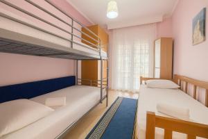 a bedroom with two bunk beds and a window at Casa d'Angelo by Horizon Homes in Orfánion