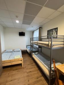 a room with two bunk beds and a table at Pokoje Tanie Spanie in Zator