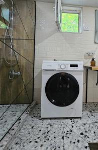 a washing machine in a bathroom with a shower at LIME Shekvetili in Shekhvetili