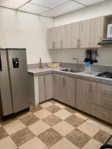 an empty kitchen with a refrigerator and a sink at Hotel Campestre El Paraíso in Guaduas +16 photos