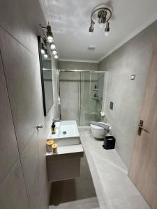 a bathroom with a sink and a shower and a toilet at Charistella Apartment in Symi +16 photos