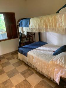 a bedroom with two bunk beds and a checkered floor at Hotel Campestre El Paraíso in Guaduas