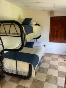 two bunk beds in a room with a checkered floor at Hotel Campestre El Paraíso in Guaduas