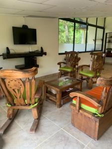 a living room with wooden furniture and a flat screen tv at Hotel Campestre El Paraíso in Guaduas