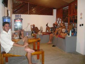 a group of people sitting on tables in a bar at Aura surf camp & Hostel in Arugam Bay