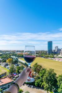 a person holding up a glass of wine at Estudio moderno con vista al Polo | Las Cañitas in Buenos Aires