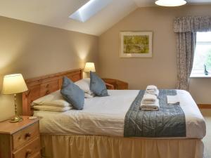 a bedroom with a bed with two towels on it at The Mill House in Warenford +10 photos
