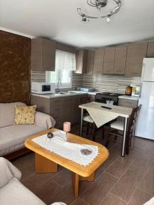 a kitchen and living room with a table and a couch at ΚΛΕΟΠΑΤΡΑ in Sfendámion