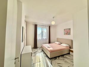 a small bedroom with a bed and a window at A&H Apartment 2 in Shëngjin