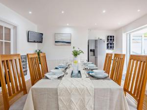 a dining room with a table with chairs and a refrigerator at 4 Bed in Combe Martin 83502 in Combe Martin