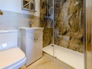 a bathroom with a shower and a toilet and a sink at 3 bed in Bamburgh 79178 in Belford +13 photos