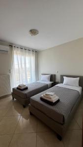 a bedroom with two beds and a large window at Vei Estate in Schinias +20 photos