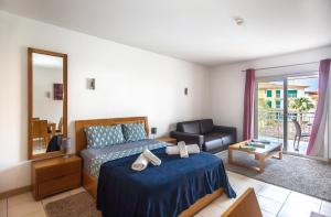 una camera da letto con un letto, una sedia e uno specchio di KÁ RICARDO - STUDIO 206 Vila Verde a Santa Maria Altre 12 foto