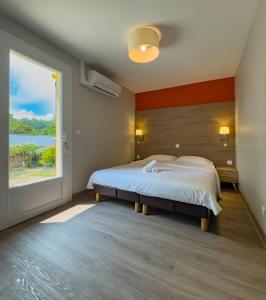 ein Schlafzimmer mit großem Bett und großem Fenster in der Unterkunft Maison double suite in Figeac