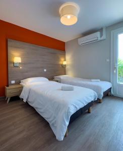 2 Betten in einem Zimmer mit orangefarbenen Wänden in der Unterkunft Maison double suite in Figeac