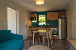 eine Küche mit einem blauen Sofa, einem Tisch und Stühlen in der Unterkunft Maison double suite in Figeac