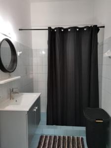 a bathroom with a black shower curtain and a sink at Valentino's Apartment 2 in Panormos Kalymnos