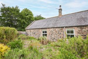 ein altes Steinhaus mit Garten davor in der Unterkunft Host & Stay - Bell Cottage in Kirknewton