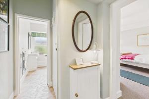 Schlafzimmer mit einem Spiegel an der Wand und einem Bett in der Unterkunft Host & Stay - Bell Cottage in Kirknewton