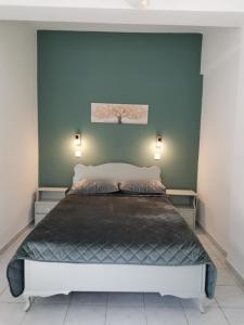 a bedroom with a large bed with blue walls at Valentino's Apartment 2 in Panormos Kalymnos