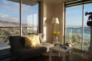 a living room with a couch and large windows at Departamento en Costanera 1D - Wifi - Parking in Antofagasta