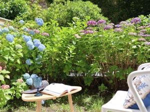 a garden with flowers and a table with a book at Portopiccolo Apartments in Sistiana