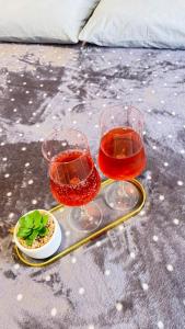 two glasses of wine and a plate of food on a table at Suítes da Orla Hospedagens in Arraial do Cabo +17 photos