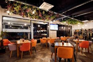 a restaurant with tables and chairs and flowers on the wall at Mamaia Sea Vibe in Mamaia Sat/Năvodari