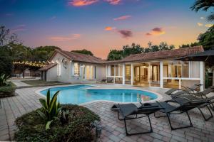 a swimming pool with chairs and a house at Firepit, Beach, Basketball, LuxuryVilla in Palmetto Bay