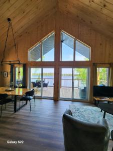 a living room with a table and chairs and windows at La Belle Vie in Saint Ludger de Milot