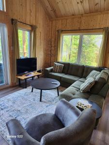 a living room with a couch and a table at La Belle Vie in Saint Ludger de Milot +21 photos